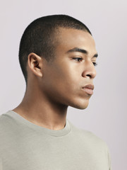 Closeup of young pensive man on colored background