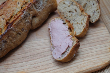 Fresh bread slice with pate on a wooden table, homemade baguette