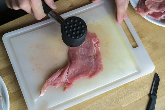 Chef tenderizing and flattening an escalope