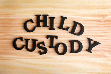 Text CHILD CUSTODY made of black letters on wooden background