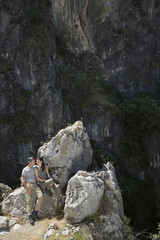 Elevated view of a relaxed couple sitting on rocks against mountains