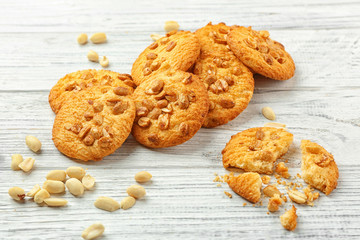 Crunchy cookies with peanuts on white wooden table