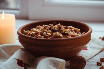 Christmas porridge with candles on white wooden background