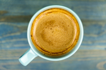 Overhead view of a cup of frothy coffee