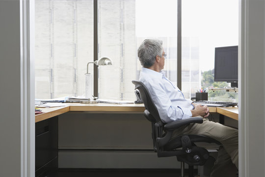 Side view of a businessman sitting at desk in office