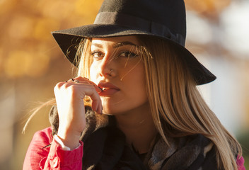Sensual blond young woman with hat and finger on her lips