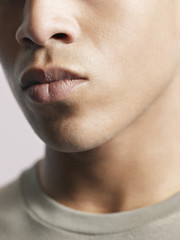 Obraz premium Closeup of young African American man's lips on colored background
