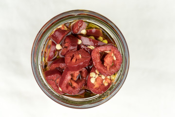 Hot sliced red cayenne chili peppers in olive oil