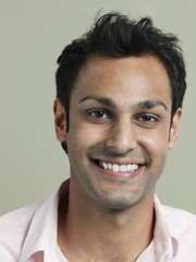 Fototapeta premium Closeup portrait of handsome young man smiling on colored background