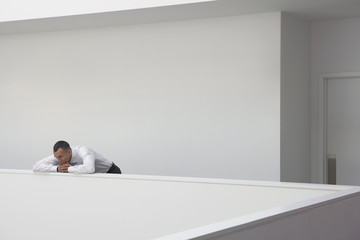 Middle aged businessman leaning on hallway balustrade
