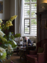 Mature businessman sitting on antique furniture and reading
