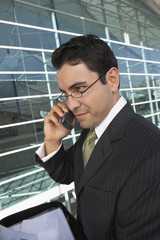 Businessman using mobile phone outside office building