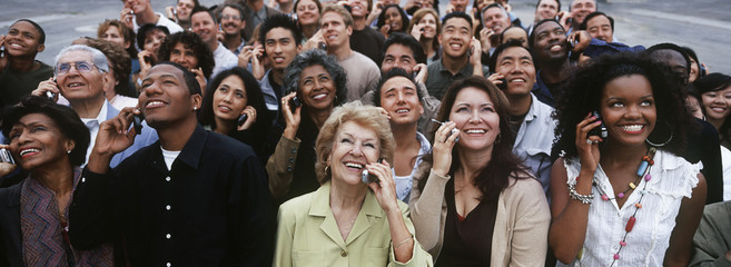 Group of happy multiethnic people using mobile phone