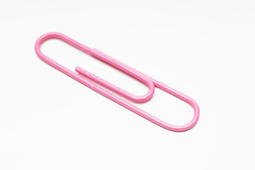 Closeup of pink paperclip over white background