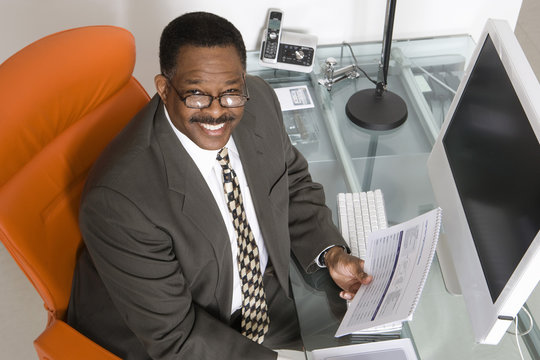 Top view portrait of a smiling African American businessman at his desk