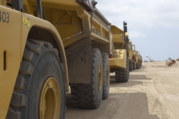 Row of trucks parked at a landfill site