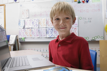 Portrait of schoolboy using a laptop in the classroom