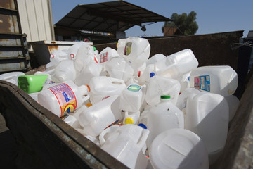 Plastic containers in bin at dumping ground