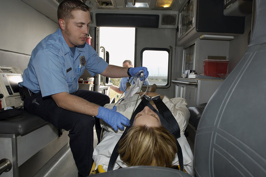 Male paramedic taking care of victim in ambulance