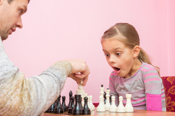 My daughter was surprised and opened her mouth when dad killed another piece on the chessboard