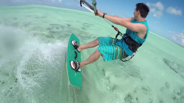 CLOSE UP: Cheerful young kitesurfer kiting in perfect blue lagoon on Zanzibar