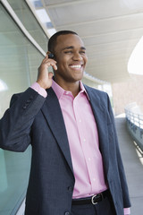 Happy businessman using hands free device on balcony