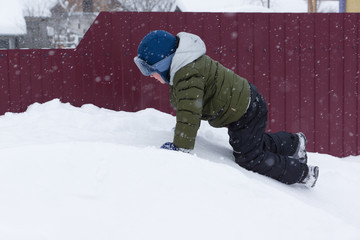 Fototapeta na wymiar Boy goes for a drive on a snowy hill
