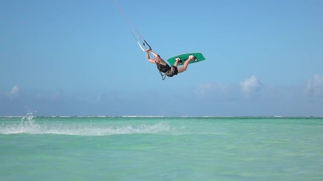 SLOW MOTION CLOSEUP: Extreme kite girl kiteboard jumping rally in blue lagoon