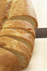 Closeup of a knife slicing baguette