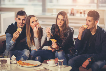 Young people in casual clothes eating pizza, talking