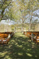 Wedding Altar with Wooden Folding Chairs Outdoors in Front of a Pond