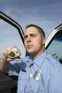 Portrait Of A Male Paramedic Using CB Radio By Vehicle