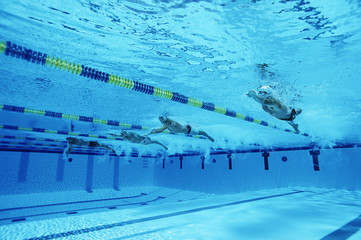 Swimmers racing together in swimming pool