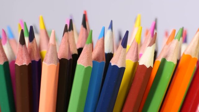 Colorful wooden pencils stand with their sharp ends up, bright colors, creative art, equipment for drawing. Close up, seamless loop, rotation, shallow DOF, 4K Ultra HD.