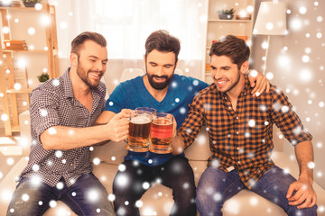 Handsome men celebrating and clinking glass of beer on xmas holi