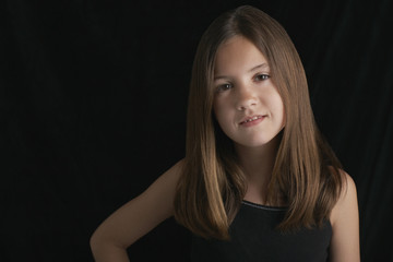 Portrait of young brunette girl against black background