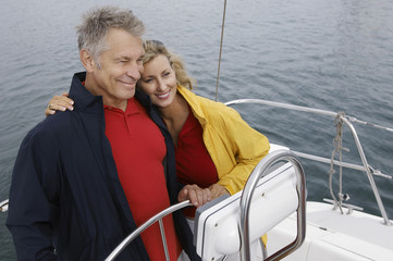 Happy Caucasian couple embracing on sail boat