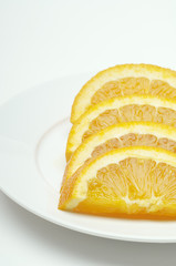 Fresh orange slices arranged in a plate isolated over white background