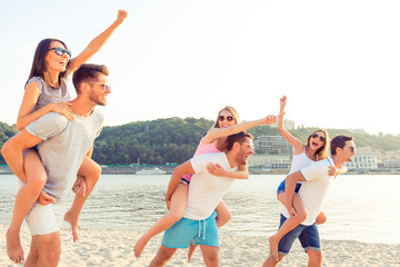 Cheerful couples enjoying weekend and having fun near the river