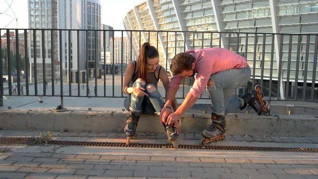 Woman and man on rollerblades. People on street background. You're so kind to me. Couple found a new hobby.
