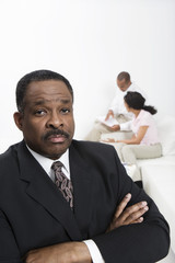 Portrait of confident financial advisor with couple in the background