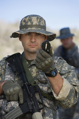 US army soldier with machine gun using compass for direction