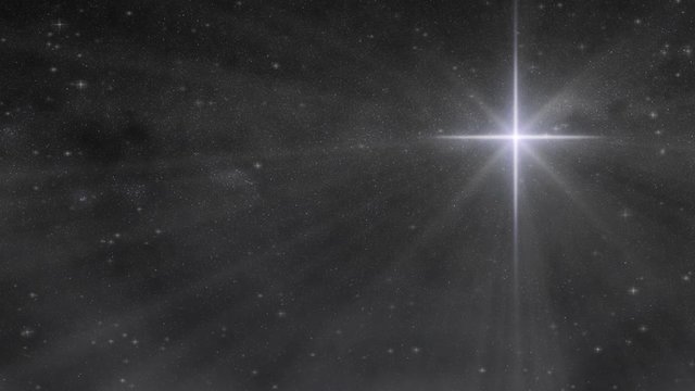 A large Christmas Bethlehem star shines in a night sky full of twinkling stars as wispy clouds pass by in this seamlessly looping motion video.