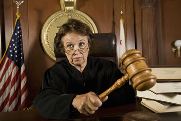 Female judge knocking a gavel in courtroom