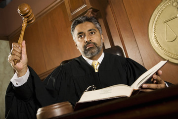 Male judge knocking gavel in the courtroom