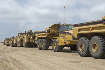 Dump trucks parked in a row at landfill site