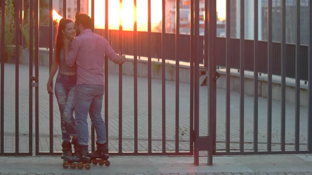 Couple on inline skates. Man touching woman's neck. Date of active people. Whisper in my ear.