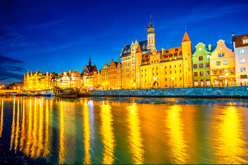 Fototapeta na wymiar Night view on the illuminated riverside with beautiful buildings of the old town in Gdansk, Poland