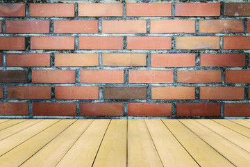 Wooden floor with colorful vintage brick wall background.