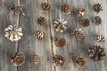 Holidays background with fir and pine cones on old wooden backg